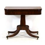 A Regency rosewood card table, the folding surface on an octagonal column with sabre legs and
