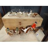 A group of Beswick hunt animals and figures including a boy and girl on ponies, a red coated