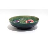 A Moorcroft bowl decorated in the 'Anemone' pattern on a green ground, d. 22 cm