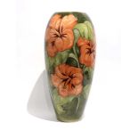 A Moorcroft vase by Walter Moorcroft decorated in the 'Hibiscus' pattern on a green ground, Queen