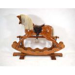 An Ian Armstrong laminated pine rocking horse on a twin pedestal base, l. 140 cm