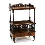 A late Victorian walnut two-tier canterbury with a fretwork gallery and single drawer, on turned