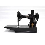 A cased Singer 221 featherweight free-arm sewing machineThere is a foot pedal, 3 spools and some