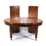 A 19th century mahogany oval extending dining table with two fitted leaves on turned legs with