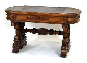 A Victorian oak desk in the manner of Pugin, the tooled leather surface over a carved frieze and