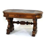 A Victorian oak desk in the manner of Pugin, the tooled leather surface over a carved frieze and