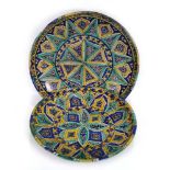 A Continental stoneware charger decorated with geometric motifs in shades of blue, yellow and