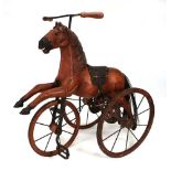 A child's tricycle in the form of a horse, h. 57 cmOperates smoothly. Some knocks and missing paint.