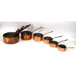 A graduated set of five vintage French copper and brass cooking pans together with another similar