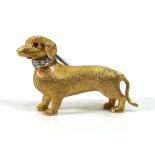 An 18ct yellow gold brooch modelled as a dachshund, its eyes set rubies, its collar set small