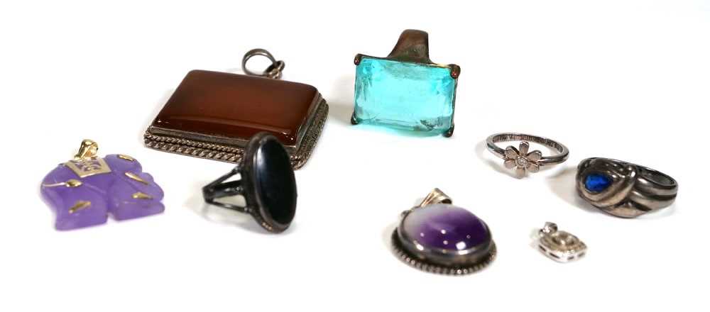 A group of silver jewellery comprising a diamond set pendant, a diamond set flowerhead ring, three