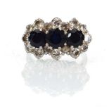 An 18ct white gold cluster ring set three sapphires within a border of sixteen brilliant cut