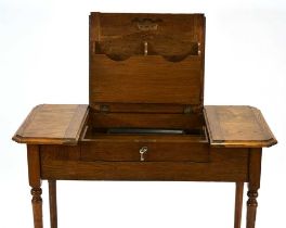 An Edwardian oak 'The Britisher Desk', patented in 1909, the surface opening to reveal a fitted