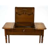 An Edwardian oak 'The Britisher Desk', patented in 1909, the surface opening to reveal a fitted