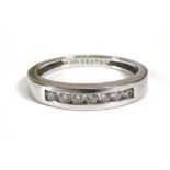 A 14ct white gold ring set seven brilliant cut diamonds in a tension channel setting,ring size N 1/