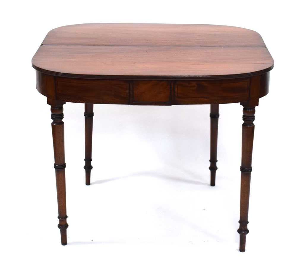 An early 19th century mahogany folding tea table, the frieze with marquetry banding, on turned