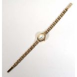 A ladies 9ct yellow gold wristwatch by Sovereign, the oval mother of pearl dial with gold coloured