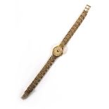 A 9ct yellow gold ladies wristwatch by Accurist, the oval dial with baton numerals and diamond at 12