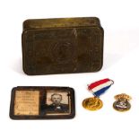 A 1914 Christmas tin together with a German aeroplane factory ID card and two badges