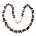 A silver necklace set clear and purple stones in twenty-five rubover flowerhead settings, l. 64 cm