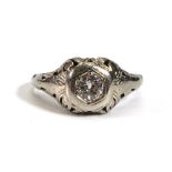 An early 20th century (?)American white metal ring set old cut diamond within a scrolled hexagonal