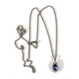 An 18ct white gold necklace, l. 54 cm, suspending a pendant set marquise shaped tanzanite within a