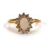 An 18ct yellow gold cluster ring set oval opal within a border of paste,ring size O,3.4 gms