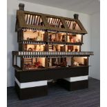 A large Robert Stubbs Tudor style electrified four storey dolls house with a large quantity of