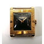 A yellow gold wristwatch movement by Jaeger Le Coultre, the square black dial with gold coloued