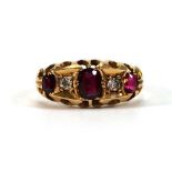 An 18ct yellow gold ring set three graduated red cut stones and two small diamonds, Chester 1914,