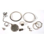 A suite of diamond set silver jewellery comprising a hinged bracelet, a pair of ear pendants, a ring