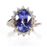 A 14ct white gold cluster ring set oval tanzanite within a border of sixteen small diamonds, central
