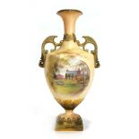 A Royal Worcester ivory blush two handled vase of urn shaped form decorated with a cottage scene and