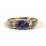 A 9ct yellow gold ring set oval alexandrite-type stone and two cubic zirconia in an inline setting,