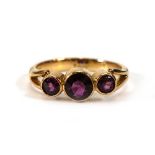 An 18ct yellow gold ring set three graduated pink stones in rubover settings,ring size L,3.8 gms