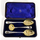 A pair of George III silver and parcel gilt berry spoons and a matching straining spoon, maker SH,
