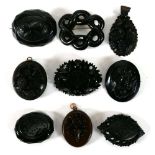 Nine jet and jet-type brooches, pendants and lockets of varying designs (9)