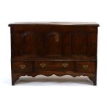 An 18th century oak mule chest, the chamfered surface over three front panels, three drawers and a