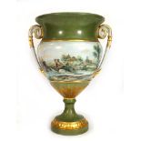 A two handled vase of urn shaped form, hand decorated with a river village landscape, signed Orla