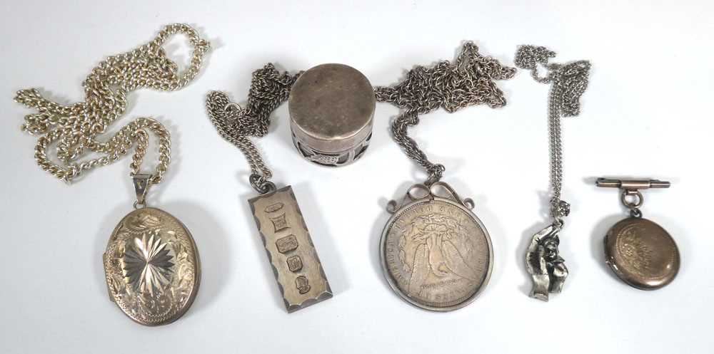 A group of silver and metalware jewellery comprising a locket necklace, an American dollar pendant