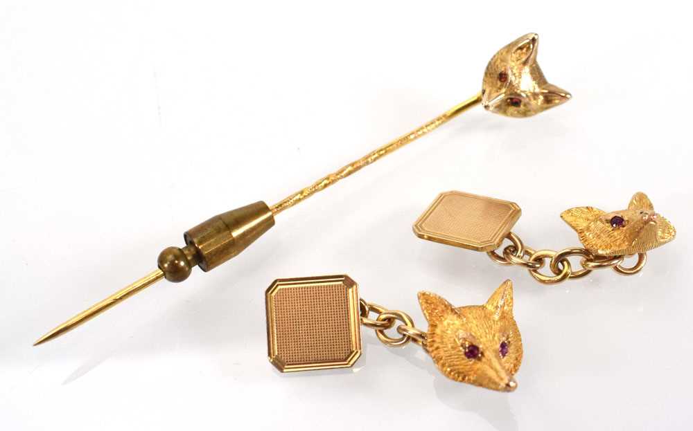 A pair of 9ct yellow gold cufflink's, each in the form of a fox's head, its eyes set small rubies,