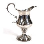 A George III silver cream jug with beaded c-scroll handle raised on a conforming base, maker EM,