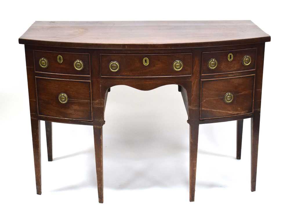 A George III mahogany bow-fronted sideboard with an arrangement of four drawers on square tapering