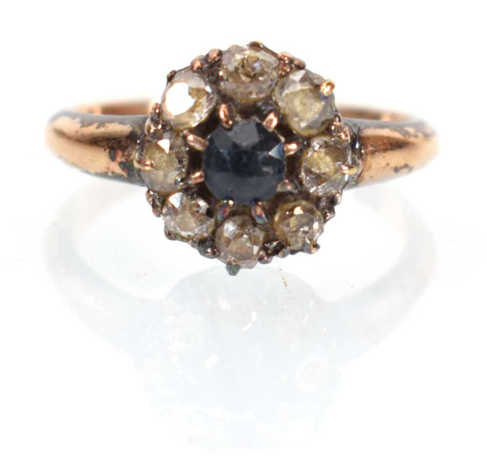An early 20th century 15ct yellow gold cluster ring set round cut sapphire within a border of