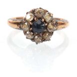 An early 20th century 15ct yellow gold cluster ring set round cut sapphire within a border of