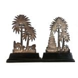 A pair of Egyptian export metalware bookends, each in the form of a palm tree on an ebonised base,