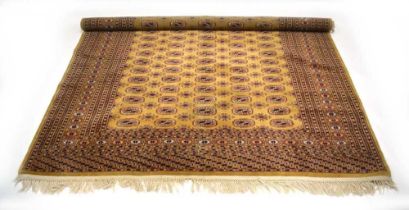 A mid-to-late 20th century carpet, the gold ground with repeated motifs within matching bands,