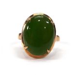 A yellow metal dress ring set cabochon green hardstone in a four claw setting,ring size M,3.1 gms