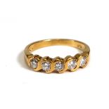 An 18ct yellow gold ring set five brilliant cut diamonds in s-shaped rubover settings,total