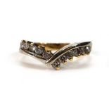 An 18ct two colour gold ring of v-shaped form set eleven small brilliant cut diamonds,ring size Q,